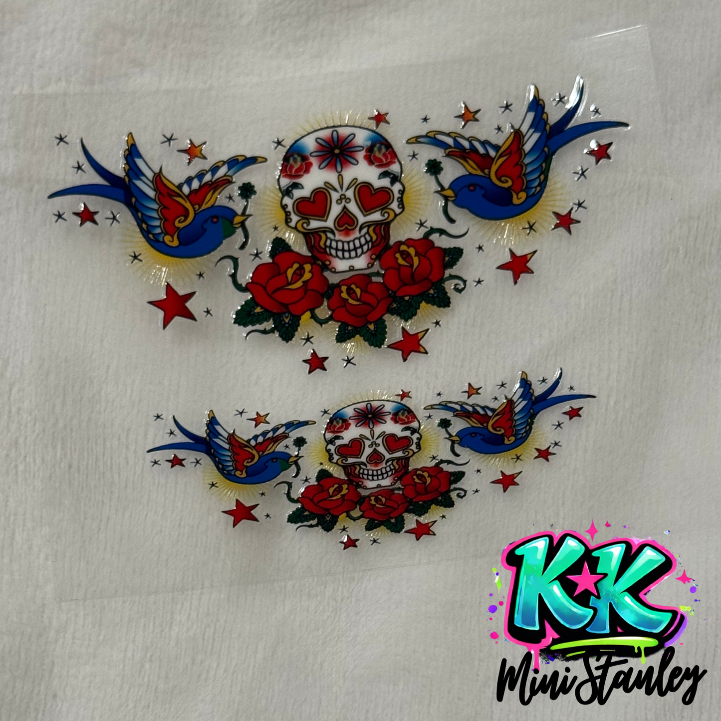 Two UV DTF adhesive transfers featuring a sugar skull, red roses, and blue swallows.