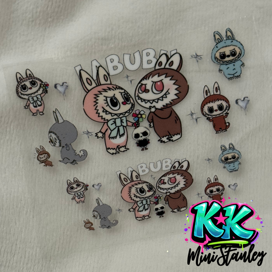 A UV DTF adhesive decal sheet featuring Labubu characters and hearts for mini keychains.