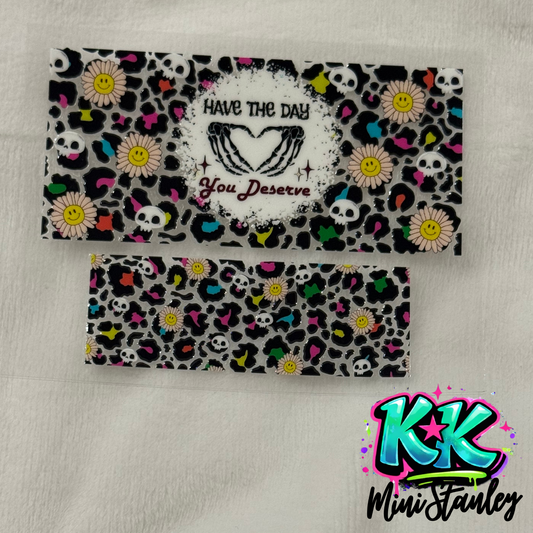 Two UV DTF adhesive wraps featuring a leopard print pattern with skulls and smiley face flowers.