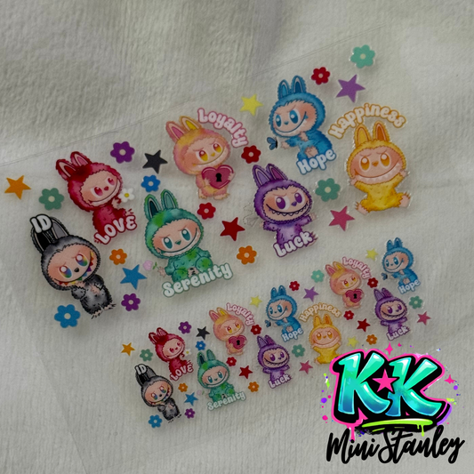 Two sheets of UV DTF adhesive transfers featuring colorful cartoon characters and text labels.