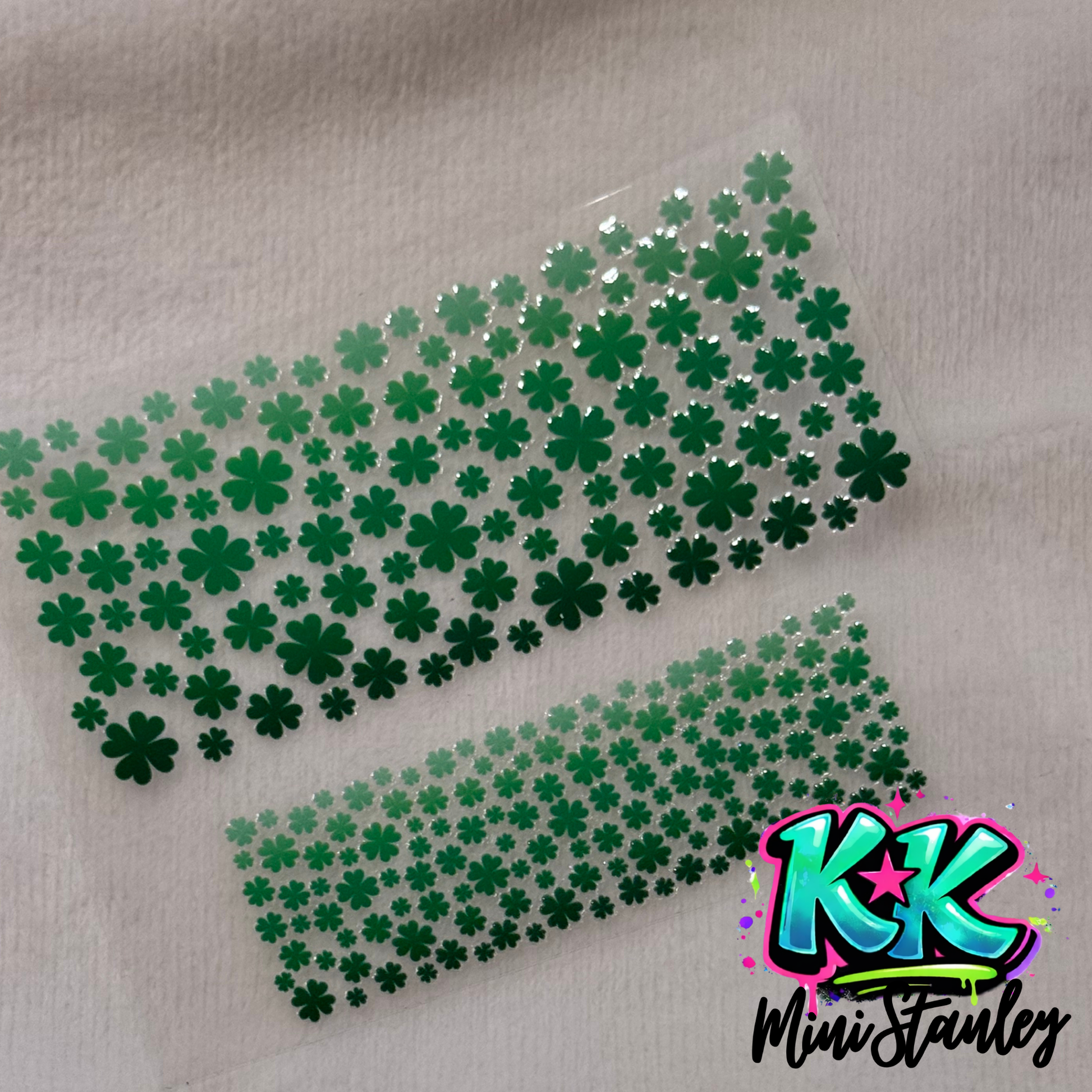 Two sheets of green shamrock clover decals for mini keychain cups on a white background.