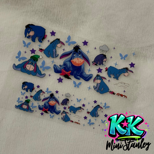 A UV DTF adhesive decal sheet featuring various Eeyore illustrations, stars, and butterflies.