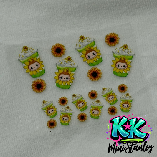 A sheet of UV DTF adhesive decals featuring sunflower-themed mini cup designs and sunflowers.