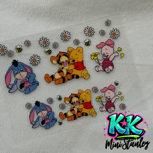 A UV DTF adhesive wrap featuring Winnie the Pooh characters, daisies, and bees for mini keychains.