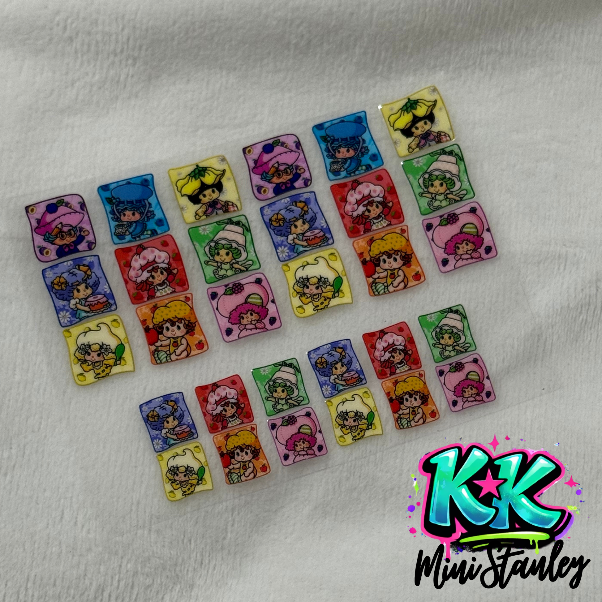 A sheet of UV DTF adhesive decals featuring various Strawberry Shortcake characters.