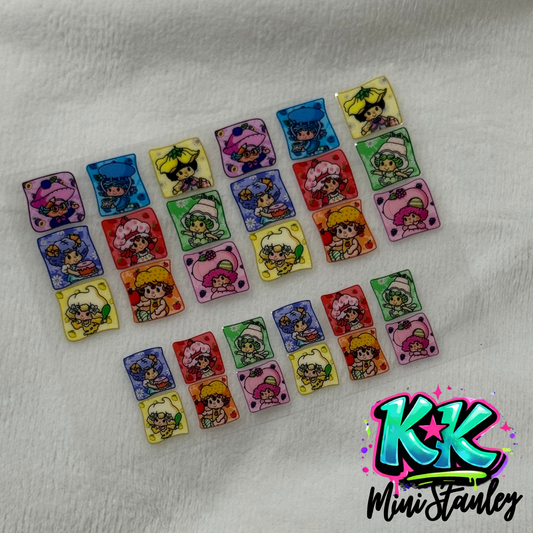 A sheet of UV DTF adhesive decals featuring various Strawberry Shortcake characters.
