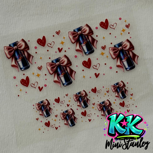 A UV DTF adhesive decal sheet featuring Red Bull cans with pink bows and hearts for mini keychains.