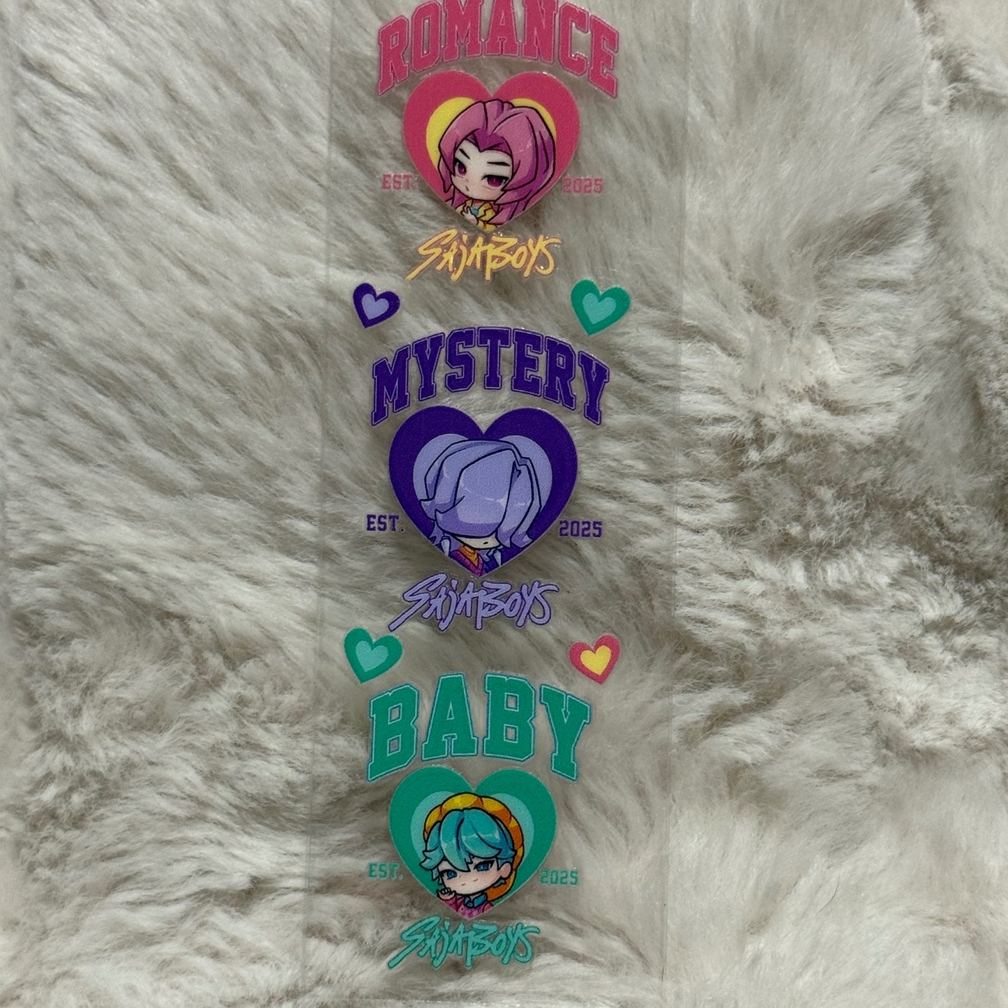 A vertical UV DTF pen wrap decal featuring three chibi characters in hearts labeled Romance, Mystery, and Baby.
