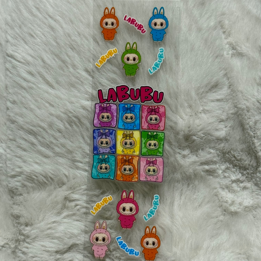 A clear adhesive pen wrap featuring colorful Labubu character illustrations and text.