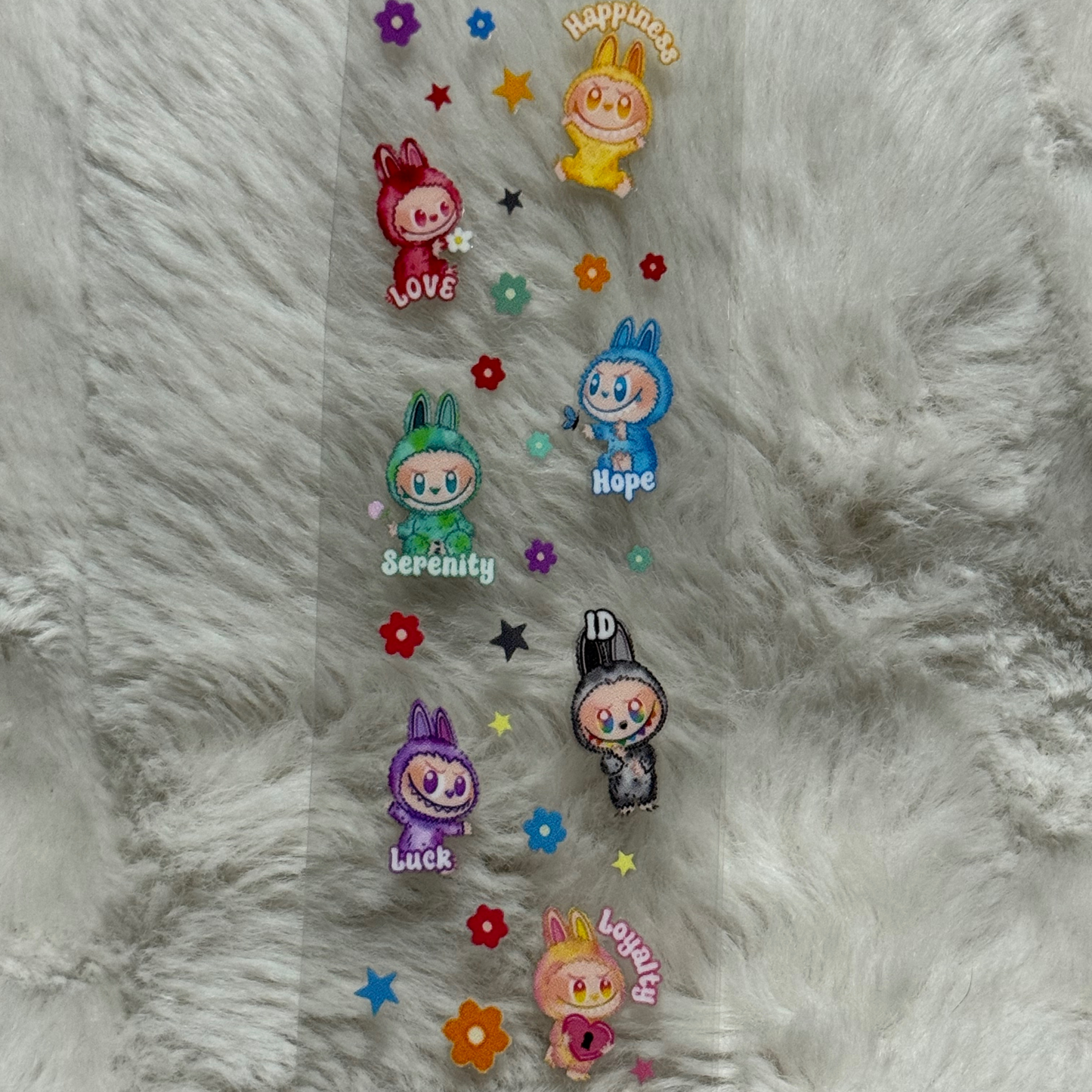 A clear adhesive pen wrap featuring colorful cartoon bunny characters with inspirational words.