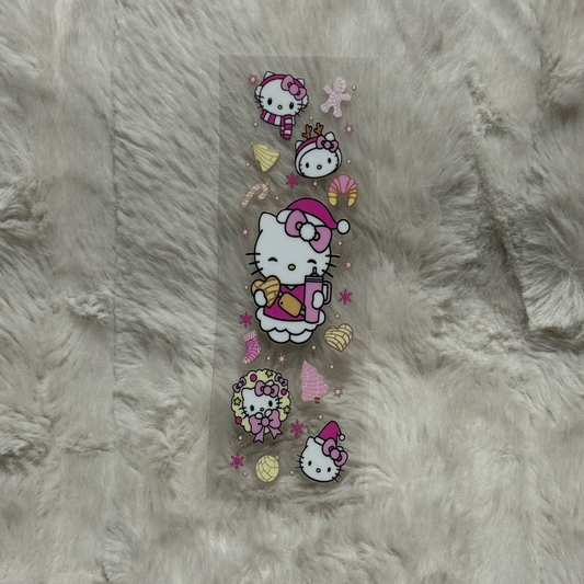 A clear adhesive pen wrap featuring Hello Kitty in holiday attire with festive treats and snowflakes.