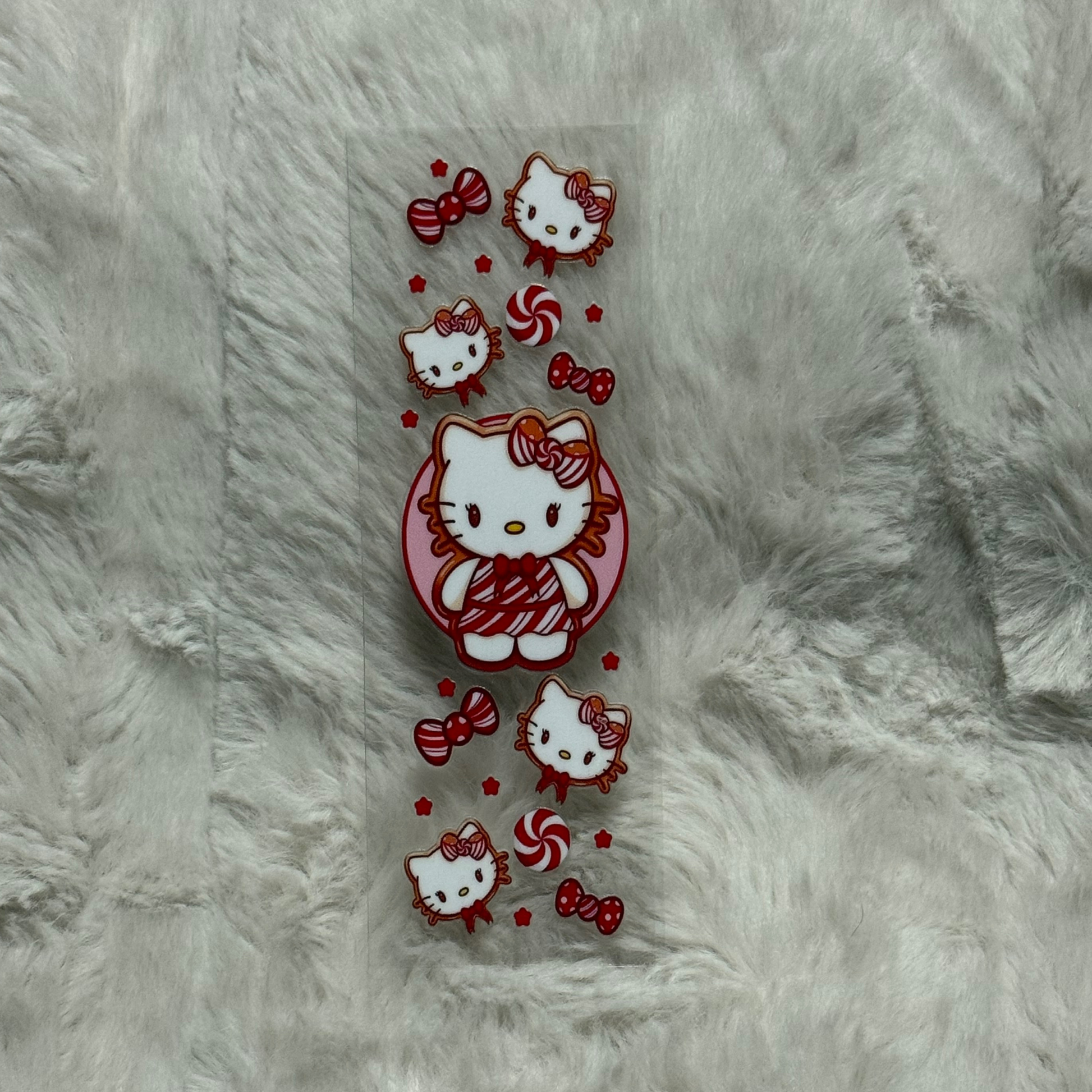 A rectangular UV DTF pen wrap featuring Hello Kitty, red bows, and peppermint candy designs.