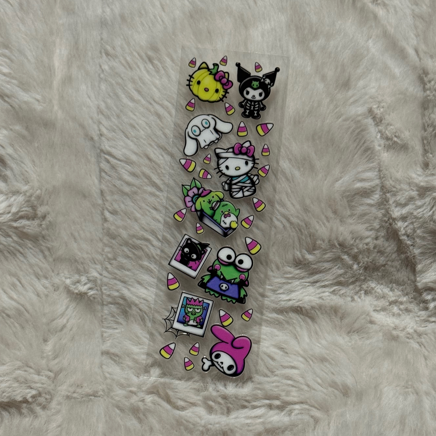 A rectangular UV DTF decal sheet featuring Sanrio characters in Halloween costumes and candy corn.
