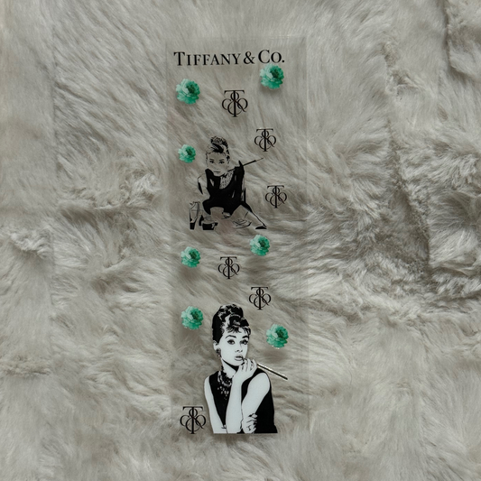 A clear UV DTF pen wrap featuring Audrey Hepburn, Tiffany and Co branding, and teal floral accents.