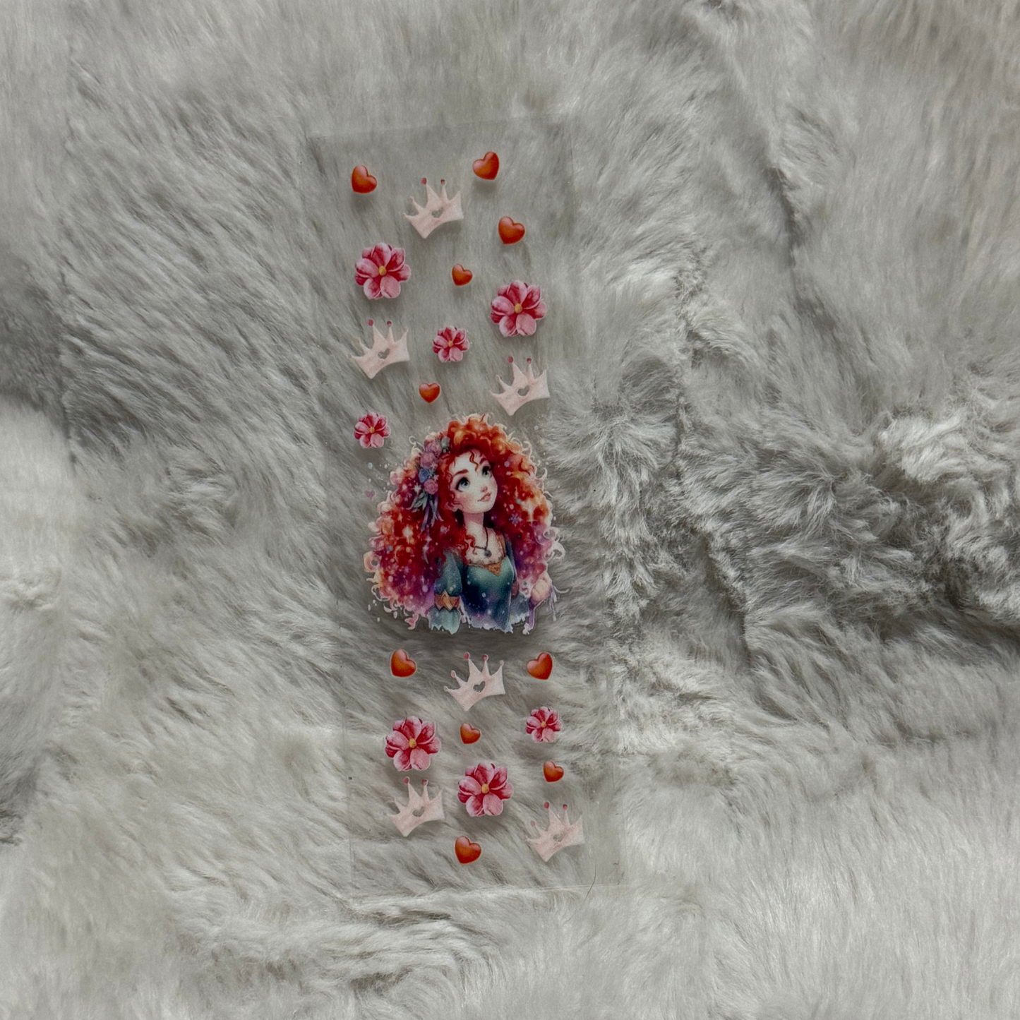 A clear UV DTF pen wrap featuring a red-haired princess surrounded by pink flowers and crowns.