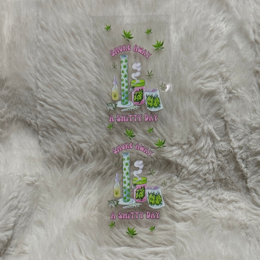A clear UV DTF pen wrap featuring two identical cannabis-themed designs on a furry background.