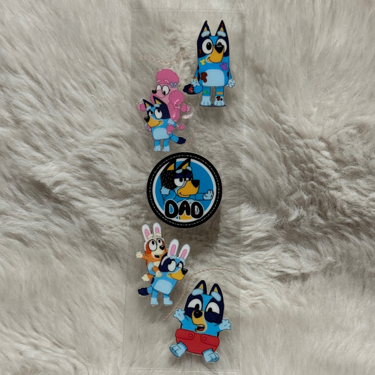 A clear adhesive pen wrap featuring various Bluey character designs on a white faux fur background.