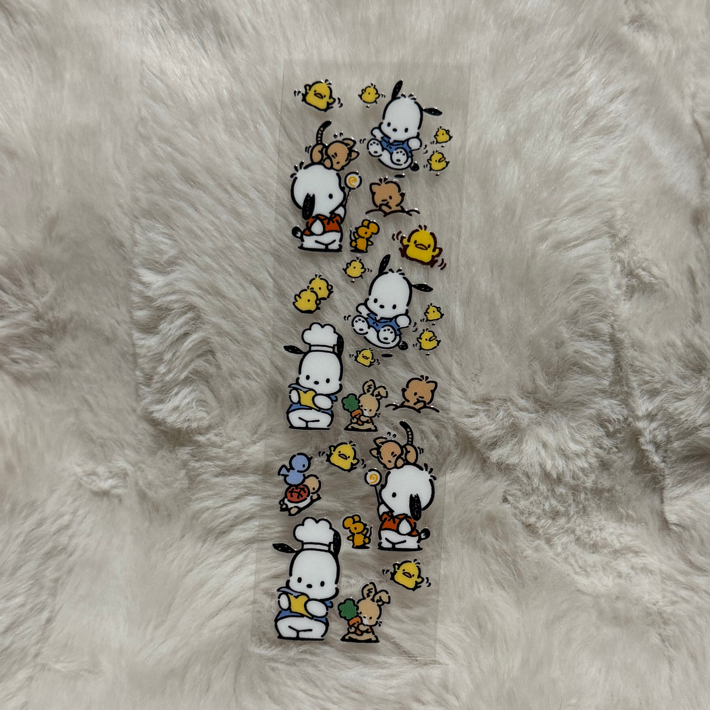 A clear adhesive pen wrap featuring Pochacco characters and small yellow chicks.