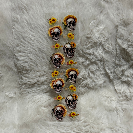 A rectangular sheet of UV DTF decals featuring skulls adorned with sunflowers.