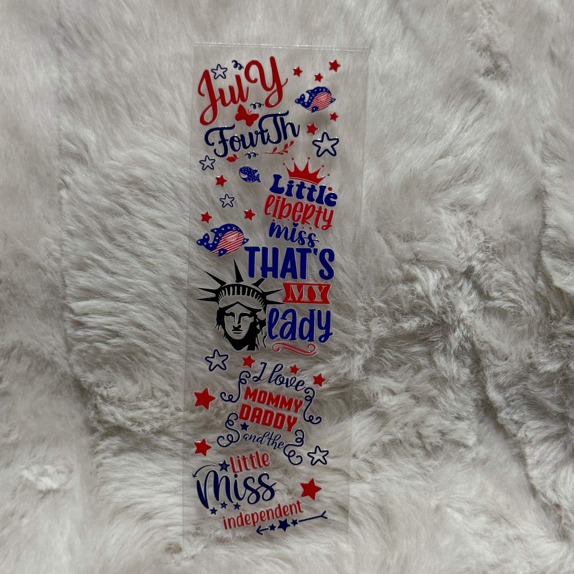 A patriotic UV DTF adhesive pen wrap featuring Fourth of July text and Statue of Liberty graphics.