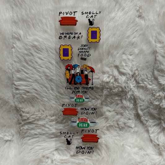 A clear adhesive pen wrap featuring various Friends-themed icons and quotes on a white fur background.
